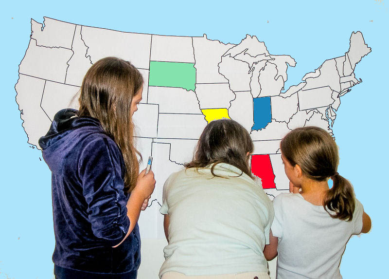 Finding states on a large wall map of the United States.